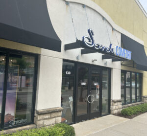 Storefront of a shop named "Scandinavian Comfort" with glass doors and large windows under black awnings.